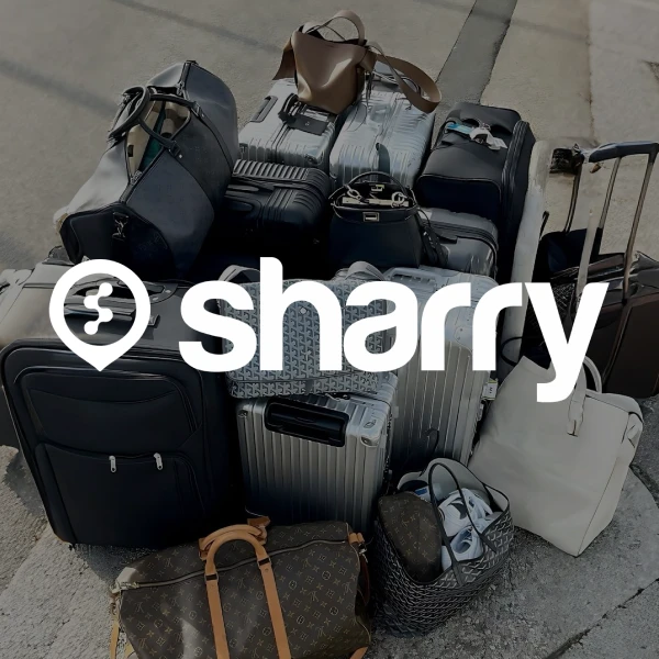 логотип і назва компанії Sharry на фоні декількох валіз різного кольору